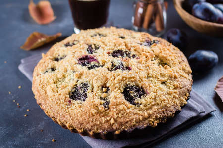 Homemade rustic plum cake on dark concrete background. Sweet fruits pie.の写真素材