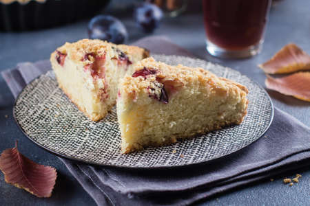 Homemade rustic plum cake on dark concrete background. Sweet fruits pie.の写真素材