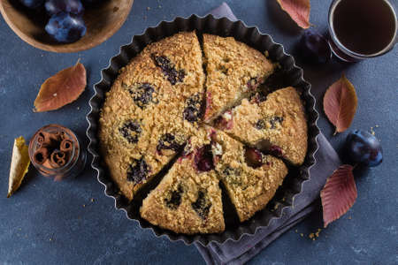 Homemade rustic plum cake on dark concrete background. Sweet fruits pie.の写真素材