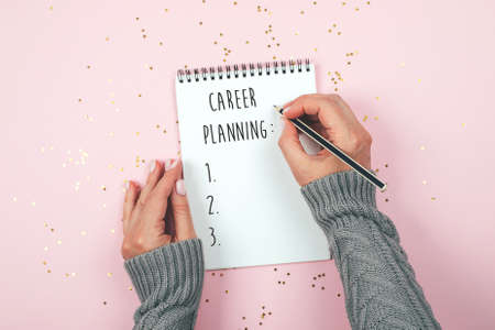 Woman's hand writing in empty notebook Career Planning. Mockup concept. Top view, flat lay, copy spaceの写真素材