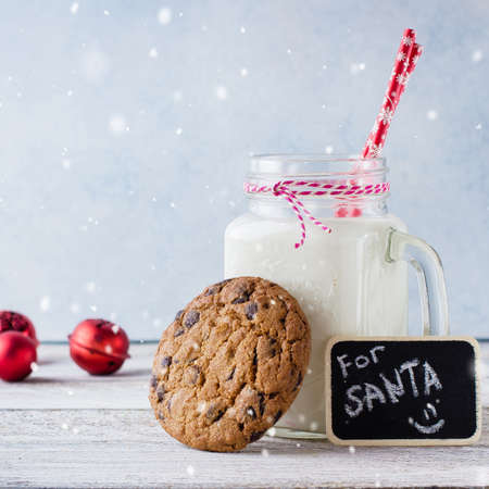 Chocolate chip cookies with a glass of milk on white wooden table background. Christmas Holiday decoration. Copy Space.の写真素材