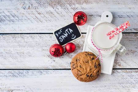 Chocolate chip cookies with a glass of milk on white wooden table background. Christmas Holiday decoration. Copy Space.の写真素材