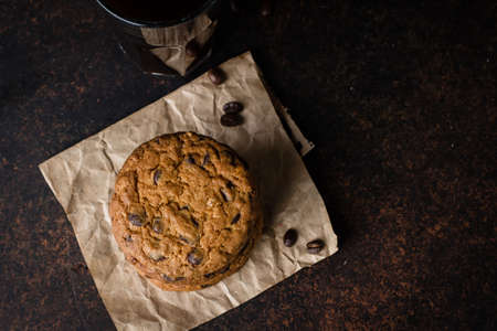 Coffee glass with chocolate chip cookie on dark stone concrete table background. Morning Breakfast...