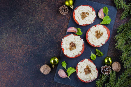 Christmas Dinner Table Setting. Delicious Snack Tomato with Grated Cheese with Garlic on dark stone table background. Top view, copy space. Festive Decoration, Fir Branchの写真素材