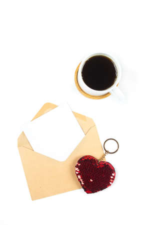 Valentines day mockup. Love card. Coffee cup and envelope with white empty blank on white background. Flat lay, top view, copy spaceの写真素材