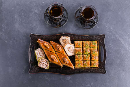 Baklava. Ramadan Dessert. Assortment of Arabic dessert with nuts and honey, cups of tea on a...