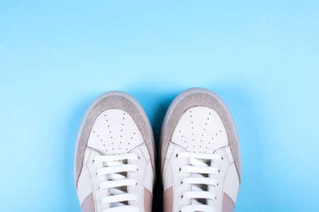 Female sneakers on blue background. Flat lay, top view minimal background. Fashion blog or magazine concept.の写真素材