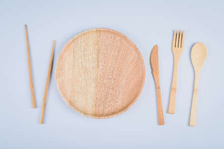 Flat lay of wooden plate and cutlery utensils on gray background. Empty plate. , food, zero waste concept. Copy space, place for objectの写真素材