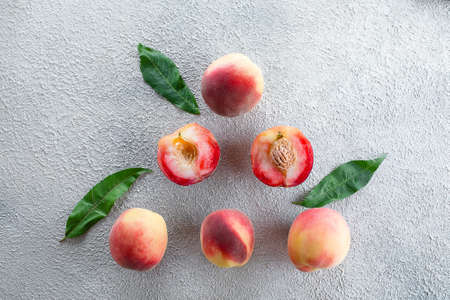 Fresh peaches. Peaches on light concrete background. Flat lay, top view.
