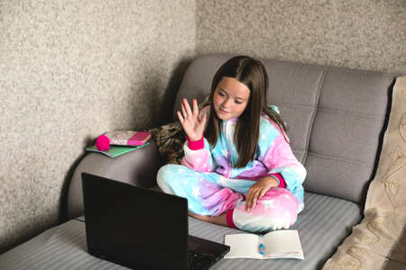Schoolgirl studying at home using laptop. Home school, online education, home education, quarantine,...