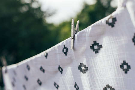 Eco- friendly laundry drying muslin diaper on clothes line.