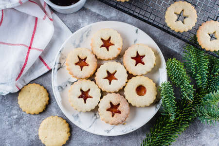 Christmas Linzer cookies with raspberry jam on concrete table background. Traditional Austrian...