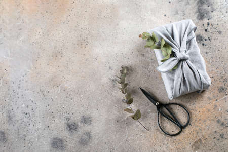 Eco-friendly fabric reusable gift packaging with eucalyptus. Sustainable gift wrapping alternative. Zero waste concept. Top viewの写真素材