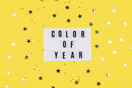 Yellow illuminating and Gray background. Flat lay, top view. Lightbox with text Color of year
