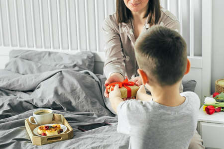 Little boy giving mother gift present box. Mother's day concept.の写真素材