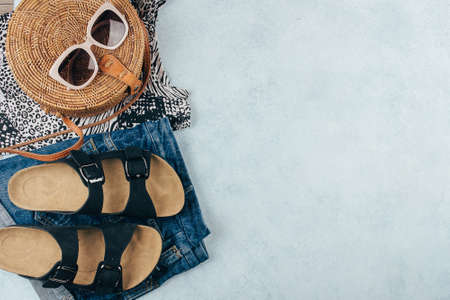 Flat lay with summer women's clothing and accessories. White t-shirt, blue denim shorts, fashionable...