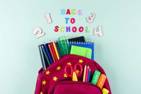 Back to school concept. School supplies in pencil case. Pink background with copy space. Flat lay, view from above.の写真素材