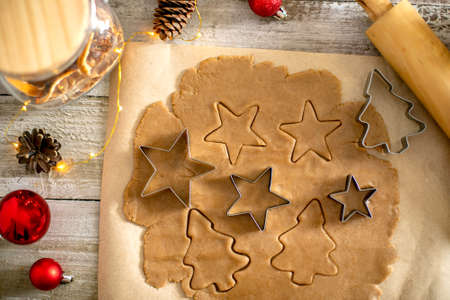 Preparation of festive christmas gingerbread cookies. Raw dough, cutting cookie and holiday decorationの写真素材