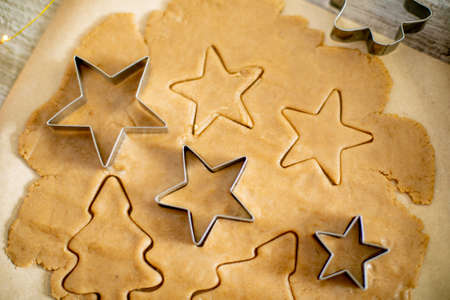 Preparation of festive christmas gingerbread cookies. Raw dough, cutting cookie and holiday decorationの写真素材