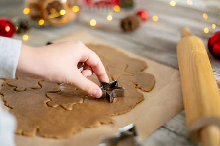 Preparation of festive christmas gingerbread cookies. Raw dough, cutting cookie and holiday decorationの写真素材