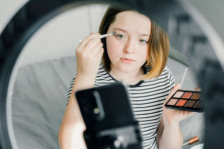 Teen girl blogger recording video for beauty blog. Blogging, videoblog, makeup concept. Young Blogger Concept.の写真素材
