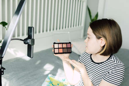 Caucasian teen girl speaking in front of camera for vlog. Teenager working as blogger, recording video tutorial for blog at home. Young Blogger Concept.の写真素材