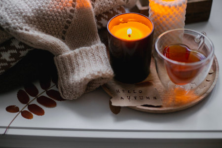 Woman drinking tea and a reading book. Cozy autumn at home.の写真素材