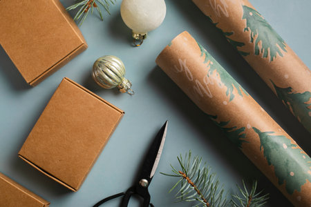 Christmas background with gift boxes, fir tree branches, wrapping paper and decorations on blue bachground. flat layの写真素材