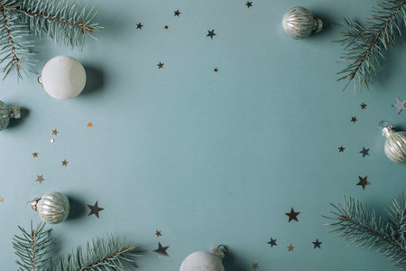 Winter holidays concept. Top view photo of fir tree branches and festive decoration on blue...