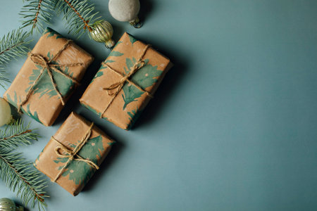 Christmas gift boxes, decoration and fir tree branch on blue background. Flat lay, top view with copy space.の写真素材