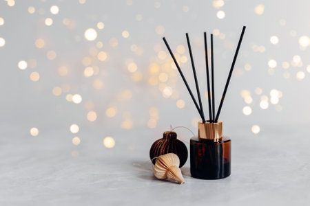 Home aroma fragrance diffuser and burning candles on wooden table in the bedroom. Interior elements. Christmas and Winter decoration. Copy spaceの写真素材