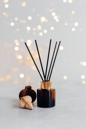 Home aroma fragrance diffuser and burning candles on wooden table in the bedroom. Interior elements. Winter decoration. Copy spaceの写真素材