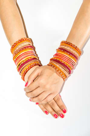 Orange and Red Bangles worn on arms isolated against white
