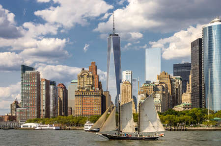 New York, NY - September 10, 2014 : A view of  Lower Manhattan skyline with a sailing boat and skycrapers over East river in Manhattan, New York, USAのeditorial素材