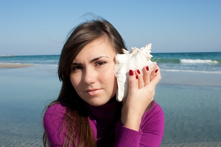Girl smiling and holding a seashell