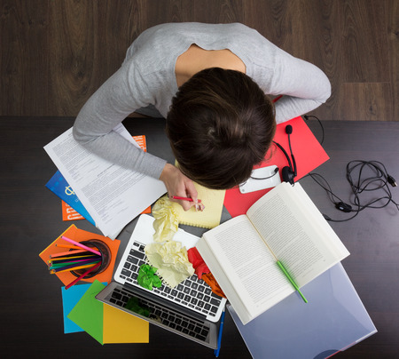 Girl working at the chaotic workplaceの写真素材