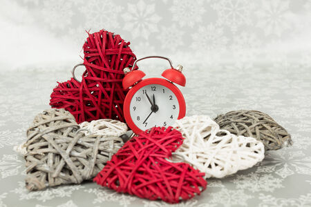 Christmas present and red clock on a snowy backgroundの写真素材