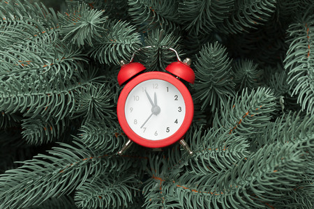 Christmas present and red clock on a snowy backgroundの写真素材