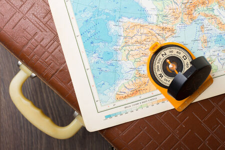 Vintage travel suitcase with map and compassの写真素材