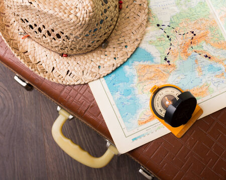 Vintage travel suitcase with map and compassの写真素材
