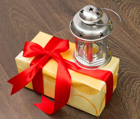 Present with red ribbon and candle lampの写真素材