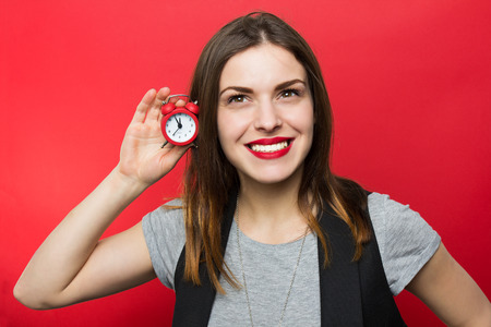 Beautiful woman holding red clock