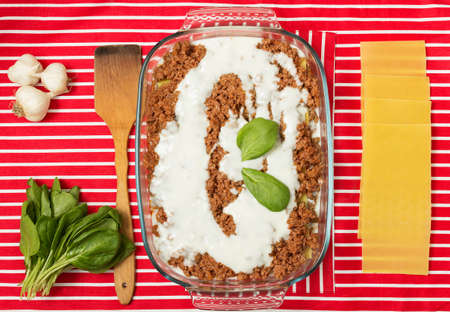 Making of tasty Italian lasagna on a bright backgroundの写真素材
