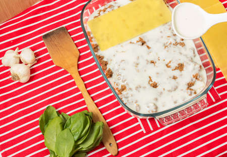 Making of tasty Italian lasagna on a bright backgroundの写真素材
