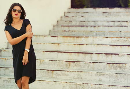 Stylish young woman standing by the stairsの写真素材