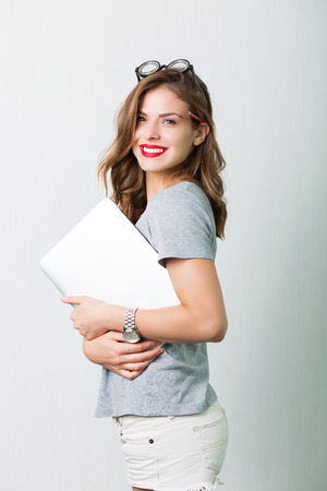 Attractive young woman holding reading glassesの写真素材