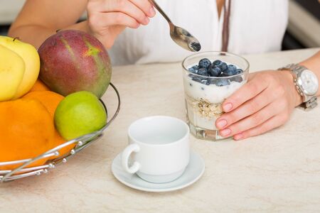 Beautiful woman having a bowl of cereals for breakfastの写真素材