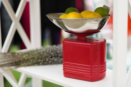 Limes and lemons on the red scales at the street marketの写真素材