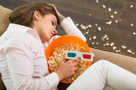 Pretty woman fell asleep while watching the movieの写真素材