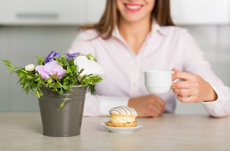 Pretty woman enjoying morning coffee with a cake